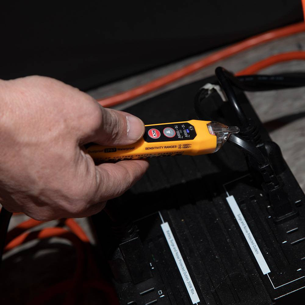 Klein Tools NCVT3P 12V to 1000V AC Dual Range Non-Contact Voltage Tester with Flashlight showing in use on exposed coated wires
