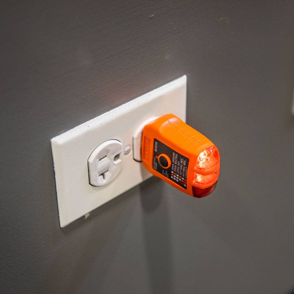 Klein Tools RT210 GFCI Receptacle Tester showing in use testing an interior plug