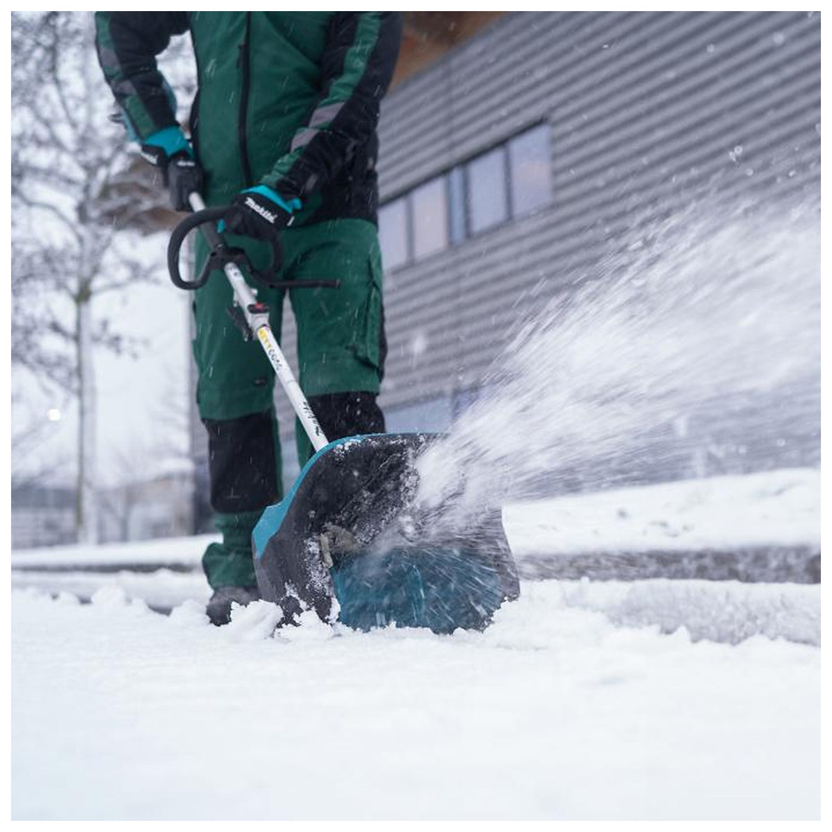 Makita SN400MP attachment throwing snow outside a building