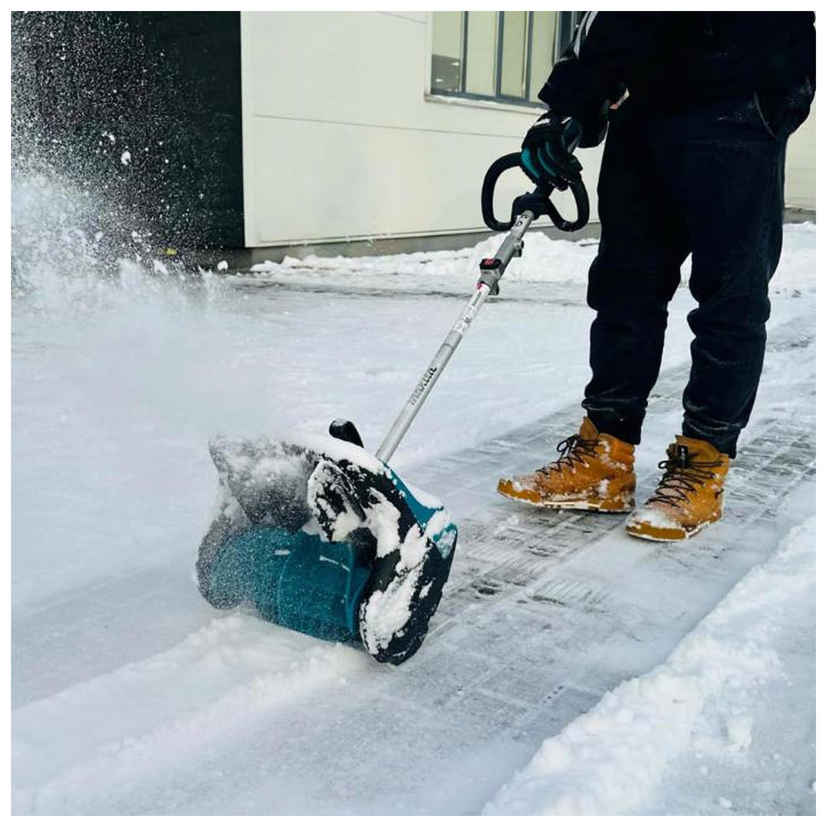 Makita SN400MP attachment clearing an icy walkway