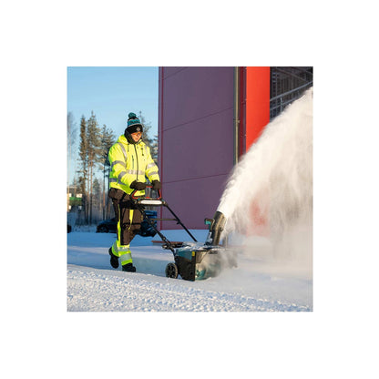 Makita SN001G snow blower clearing snow beside a building