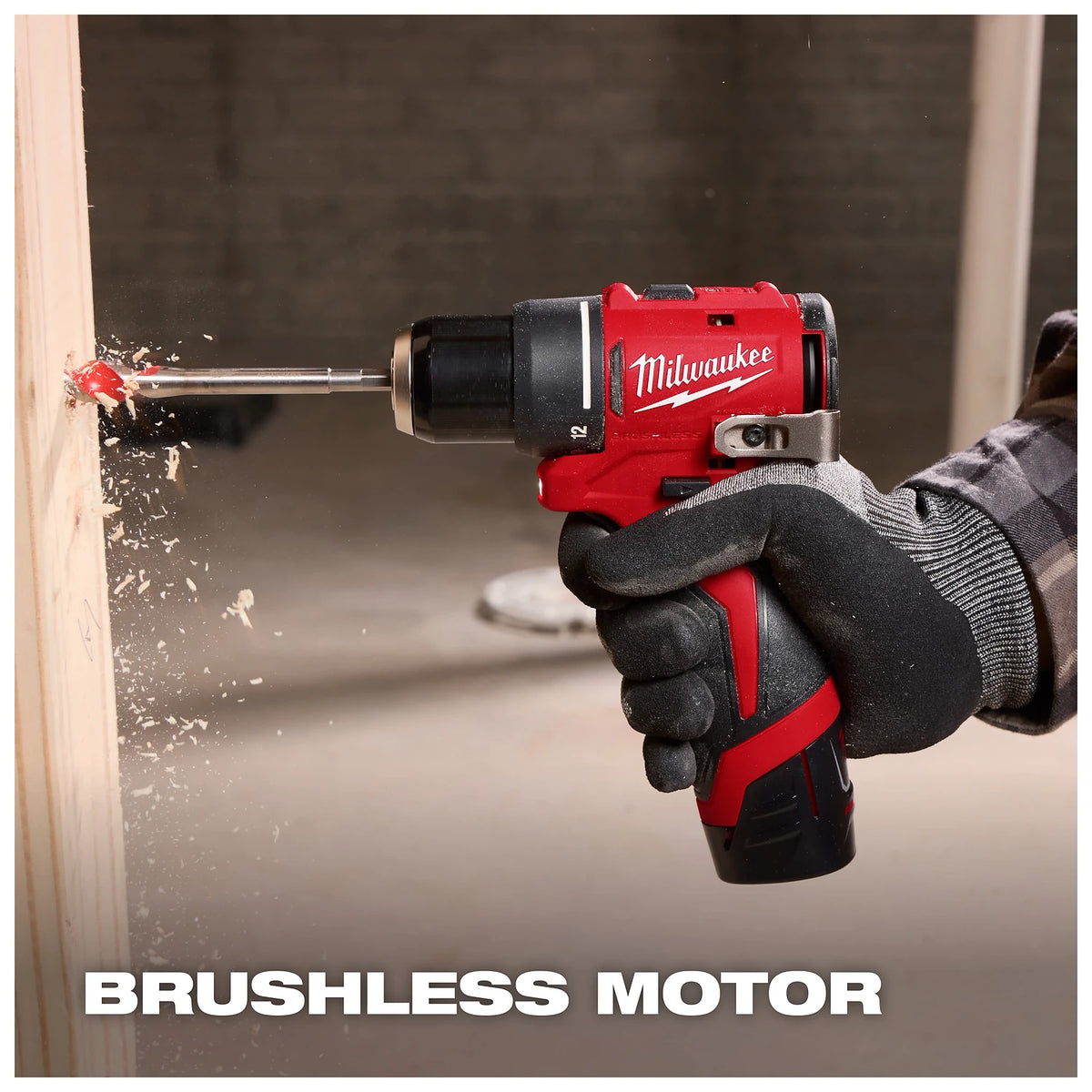 A gloved person uses a red Milwaukee drill with a brushless motor to bore through a light-colored wooden plank, generating wood shavings. The background is blurred, and text reading "BRUSHLESS MOTOR" is at the bottom of the image.