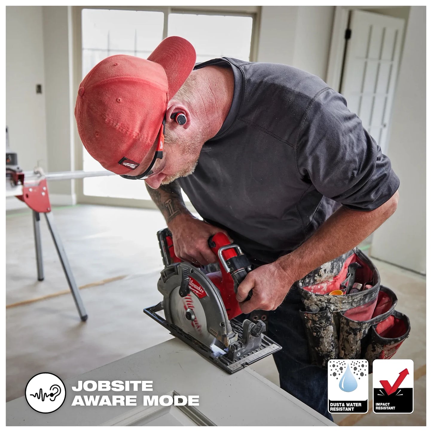 Worker on the jobsite wearing the Bluetooth ear buds while using a Milwaukee circular saw