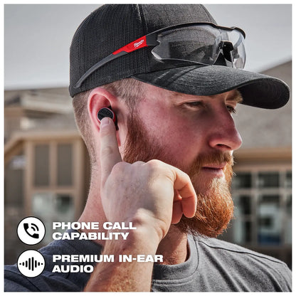 Worker on the jobsite using the Bluetooth ear buds to make a phone call
